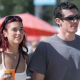 Dua Lipa sparks engagement rumors with Callum Turner after being spotted with a ring. Fans await official confirmation.